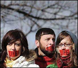 Protesters with red tape over their mouths.